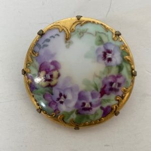 Z124- Vintage brooch with a gold colored decorative edges with a floral print.
